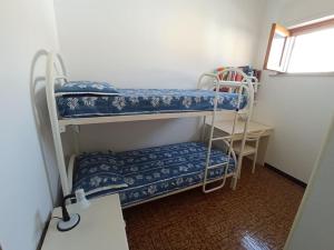 Zimmer mit 2 Etagenbetten und einem Tisch in der Unterkunft La casa di Carlo in SantʼAntìoco