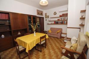 ein Wohnzimmer mit einem Tisch und einem gelben Tischtuch in der Unterkunft La casa di Carlo in SantʼAntìoco