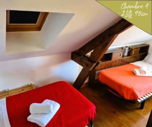 pokój na poddaszu z dwoma łóżkami i czerwonym kocem w obiekcie VILLA ANNEE 30 Rénovée ,Terrasse et Jardin w mieście Souillac