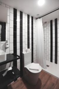 czarno-biała łazienka z toaletą i prysznicem w obiekcie Alma Candida 02 w mieście Valença