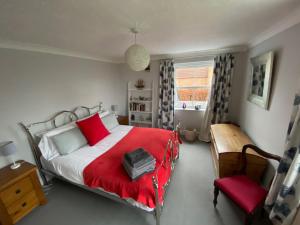 a bedroom with a red bed and a red chair at Beautiful country house in Inkpen in Inkpen