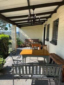 a wooden table and chairs on a patio at Bekkersvlei - Die Huis in Haenertsburg
