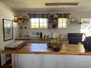 cocina con encimera de madera y mesa de madera en Bekkersvlei - Die Huis, en Haenertsburg