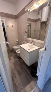 a bathroom with a sink and a toilet and a mirror at Holiday Apartments Bellariva in Riva del Garda