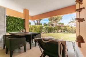 patio ze stołem i krzesłami oraz dziedzińcem w obiekcie COTOVIA VILLA luxury and golf vacations w mieście Quinta do Lago