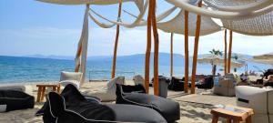 a beach with chairs and umbrellas and the ocean at Apartment Marina 1 in Asprovalta