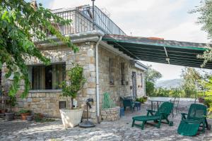 a stone house with green chairs and a patio at Villa Ada - Casale nel Sannio in Torrecuso +27 photos