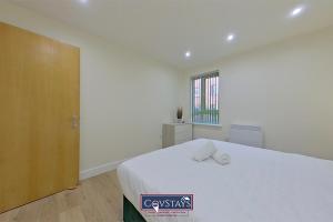 a bedroom with a large white bed and a window at Beauchamp House - Apartment in Coventry City Centre, Sleeps 4, Free secure parking, by CovStays in Coventry