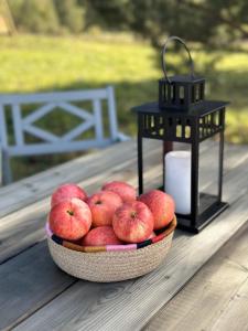 una ciotola di mele su un tavolo accanto a una lanterna di Briedžio sapnas a Sudervė