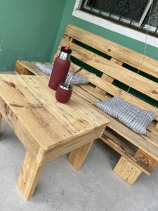 a wooden picnic table with a red thermos on it at Apto en Minas con amplio fondo, aire acondicionado, ideal para descansar in Minas