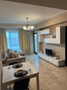 a living room with a couch and a table and a tv at Copou Central Linden Suite in Iaşi +46 photos