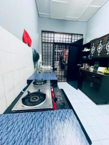 - une cuisine avec une cuisinière dans une chambre dans l'établissement Daliya Homestay Ulu Tiram JB, à Ulu Tiram