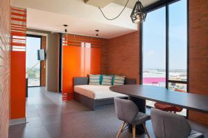 a bedroom with a bed and a table with chairs at Aloft Celaya in Celaya