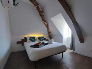 a bed with a tray of food on it in a room at Edera in Saint-Aignan