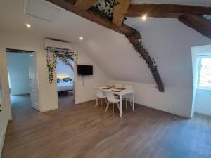 a room with a table and chairs and a bedroom at Edera in Saint-Aignan