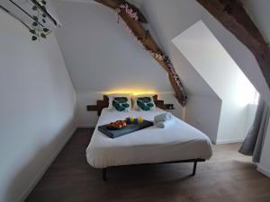 a bedroom with a bed with a tray of food on it at Edera in Saint-Aignan