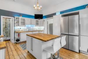 a kitchen with white cabinets and a wooden floor at Brooklyn Villa in Norwich