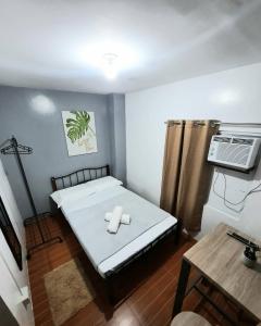 a small room with a bed and a air conditioner at Studio type unit - Host Homes Apitong in Tacloban