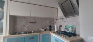 a kitchen with blue cabinets and a sink and a stove at La mia Marì in Palestrina