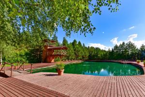 a swimming pool with a wooden deck and a tree at Aerodream Trakai in Antakalnis