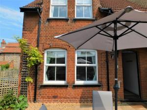 an umbrella in front of a brick building at 1 Orchard Cottages in West Runton