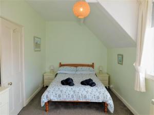 a bedroom with a bed with two towels on it at 1 Orchard Cottages in West Runton