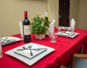 una mesa con un mantel rojo con una botella de vino en Jackie Grand Hotel, en Cape Coast