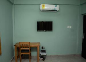 mesa y silla en una habitación con aire acondicionado en Jackie Grand Hotel, en Cape Coast