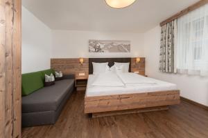 um quarto com uma cama e um sofá em Haus Margret em Sankt Leonhard im Pitztal