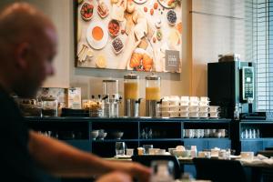 a man sitting at a table in a restaurant at Serwir Hotel in Sint-Niklaas