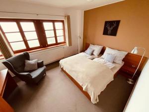 um quarto com uma cama e uma cadeira em Hotel Oddech em Pec pod Sněžkou