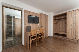 Zimmer mit einem Tisch und einem TV an der Wand in der Unterkunft Haus Margret in Sankt Leonhard im Pitztal