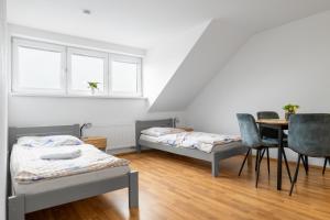 Habitación con 2 camas, mesa y sillas en Apartmány Borská Plzeň, en Plzeň