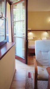 a room with a bedroom with a bed and a window at Wellness Hotel Ambra in Luhačovice