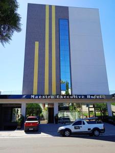 HOTEL MAESTRO EXECUTIVE PATO BRANCO في باتو برانكو: سيارة شرطة متوقفة أمام مبنى كبير