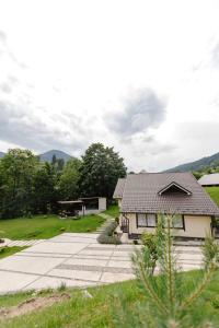 een klein huis met een tuin en een veld bij Вілла у горах in Krasnik