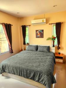 a bedroom with a bed and two windows at Villa for rent in Ko Chang