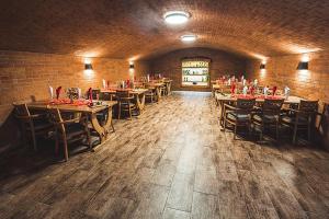 a dining room with tables and chairs and a brick wall at Hotel Ambra in Luhačovice