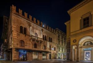 une rue vide dans un vieux bâtiment la nuit dans l'établissement Hotel Posta, à Reggio d'Émilie