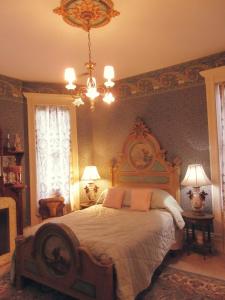 ein Schlafzimmer mit einem großen Bett und einem Kronleuchter in der Unterkunft Johnstone Mansiion in Keokuk