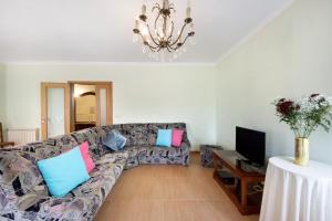 a living room with a couch and a tv at Vivenda Sol e Mar in Gafanha da Nazaré