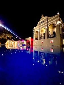 a building at night with its lights in the water at Je t'aime cafe & villa in Sing Buri