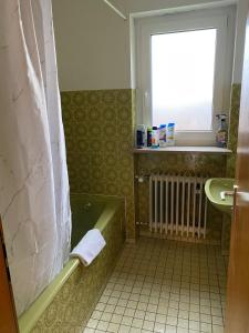 W łazience znajduje się zielona wanna i umywalka. w obiekcie Gästehaus Rachinger w mieście Pappenheim