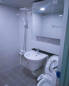 Łazienka z białą toaletą i umywalką w obiekcie Subhanallah guest house w mieście Yangsan
