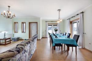 a dining room with a long table and chairs at Vivenda Sol e Mar in Gafanha da Nazaré