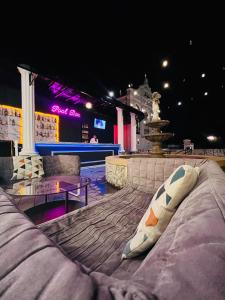 a couch sitting in front of a stage at night at Je t'aime cafe & villa in Sing Buri