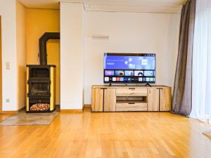 a living room with a tv and a wood stove at Relax & Business Apartment 122qm mit Balkon, Kamin und Disney+ in Sindelfingen