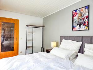 a bedroom with a bed and a painting on the wall at Relax & Business Apartment 122qm mit Balkon, Kamin und Disney+ in Sindelfingen