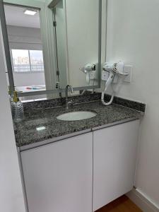 a bathroom with a sink and a mirror at TrevizZo Allianz Parque in Sao Paulo