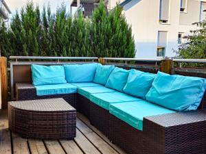 a bench with blue cushions on a wooden deck at Relax & Business Apartment 122qm mit Balkon, Kamin und Disney+ in Sindelfingen
